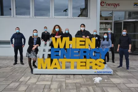 Hélène Monot, della Fondazione dell'Università di Strasburgo, e Thomas Lecourt, dell'associazione Emmaüs Connect, con i team Socomec coinvolti in questo progetto.