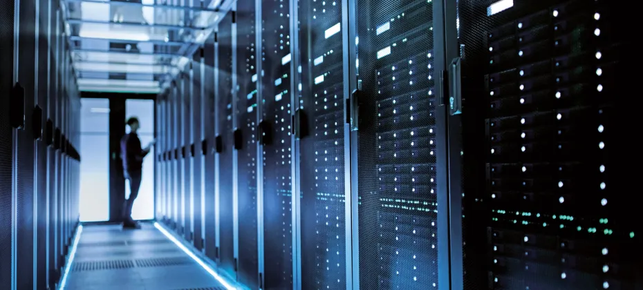 Technicien en train de contrôler les équipements au sein d'un data center pour s'assurer de la redondance de ce dernier.